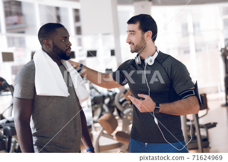 Two men communicate at racetracks in modern gym. Two men communicate at racetracks in modern gym. 71624969