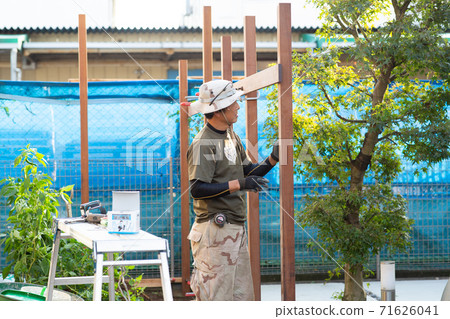 Carpenter making a fence 71626041