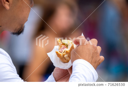 Crop man with hot dog in crowd 71626530