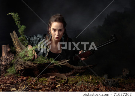 Portrait of a young woman with a rifle. 71627262
