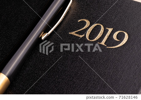 A pen on a closed black notebook diary with the inscription 2019 for doing business in the new year A pen on a closed black notebook diary with the inscription 2019 for doing business in the new year 71628146