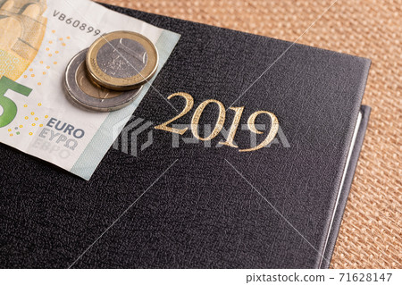 Notebook and money on the table. Notepad and euro banknotes. The concept of business planning, travel, home expenses Notebook and money on the table. Notepad and euro banknotes. The concept of business planning, travel, home expenses 71628147