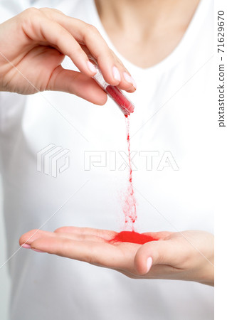 Manicurist pours red pigment nail powder 71629670