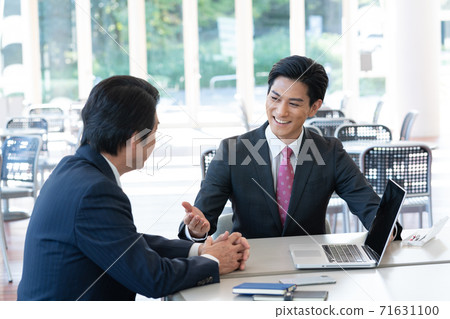 Middle-aged man talking to a young consultant man Middle-aged man talking to a young consultant man 71631100