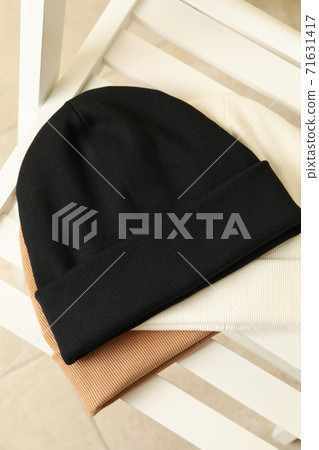 Three stylish beanies on wooden chair, top view 71631417