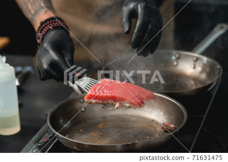 Two frying pans with tuna steak on induction stove Two frying pans with tuna steak on induction stove 71631475