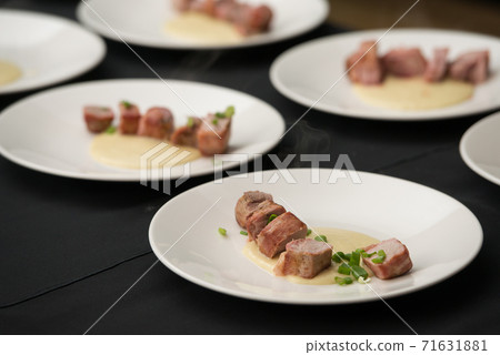 Closeup of chief serving delicious roasted pork meat wrapped in bacon. Irish traditional dish wrapped pork loin with roasted garlic 71631881