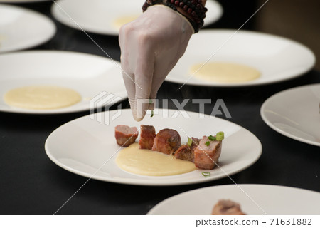 Closeup of chief serving delicious roasted pork meat wrapped in bacon. Irish traditional dish wrapped pork loin with roasted garlic Closeup of chief serving delicious roasted pork meat wrapped in bacon. Irish traditional dish wrapped pork loin with roasted garlic 71631882