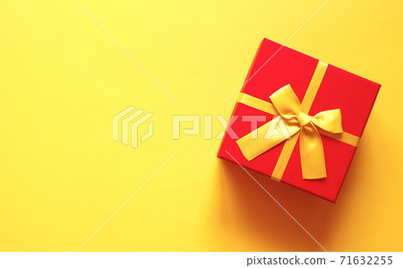 bright red gift box on yellow background bright red gift box on yellow background 71632255