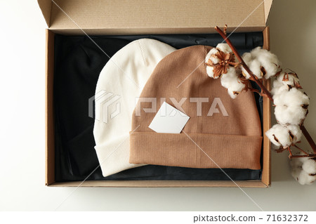 Box with beanies and cotton on white background 71632372
