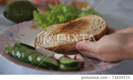 Piece of bread in hand 71634533
