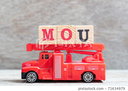 Red fire truck hold letter block in word MOU (Abbreviation of memorandum of understanding) on wood background Red fire truck hold letter block in word MOU (Abbreviation of memorandum of understanding) on wood background 71634979