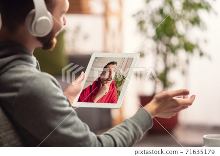 Celebration and holidays during quarantine concept. Friends or family unpacking gifts while talking using video call 71635179