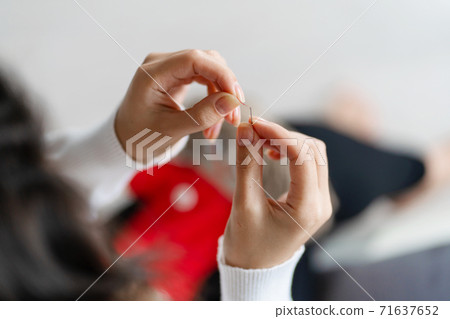 Handicraft is a fascinating hobby. The person sews dolls at their leisure Handicraft is a fascinating hobby. The person sews dolls at their leisure 71637652