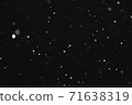 Snow illuminated by a flash flies in the dark 71638319