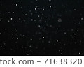 Snow illuminated by a flash flies in the dark 71638320