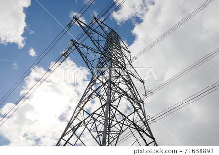Looking up at a towering metal electricity pylon and a bright sky Looking up at a towering metal electricity pylon and a bright sky 71638891