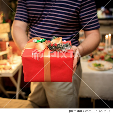 Young man holds out presents new year beautiful gift box 71639627