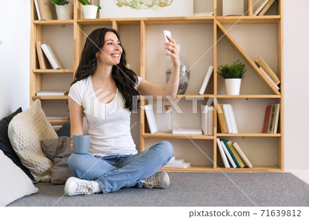 Cute happy woman holding cellphone, using mobile dating application to chat or sending message. 71639812