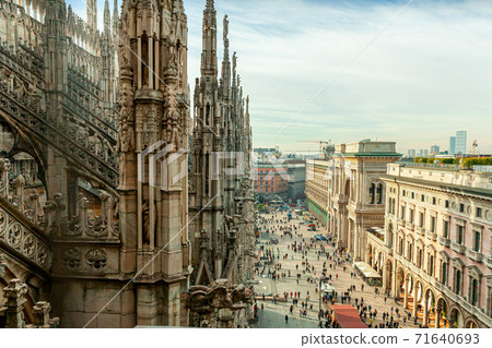 Roof of Milan Cathedral Duomo di Milano with Gothic spires and white marble statues. Top tourist attraction on piazza in Milan, Lombardia, Italy. Wide angle view of old Gothic architecture and art. Roof of Milan Cathedral Duomo di Milano with Gothic spires and white marble statues. Top tourist attraction on piazza in Milan, Lombardia, Italy. Wide angle view of old Gothic architecture and art. 71640693