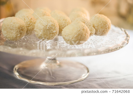 Cakes with coconut truffles in the evening light on a stand 71642068