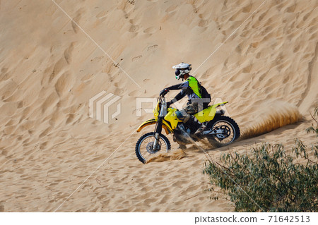 off-road motorcycle enduro motocross rider on sand dune 71642513