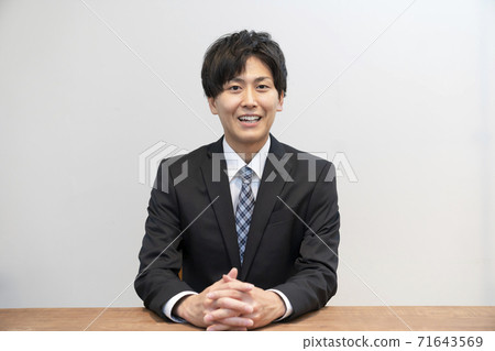穿著西裝和另一個人說話的年輕人 71643569