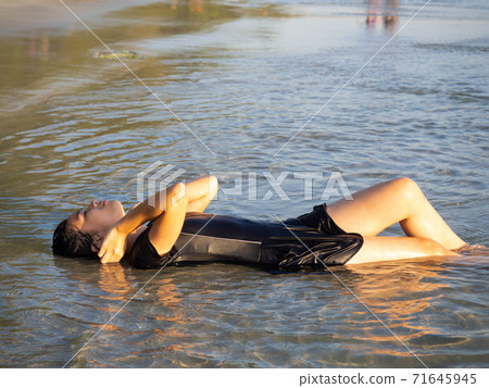 Teenage girl playing in the sea. Teenage girl playing in the sea. 71645945