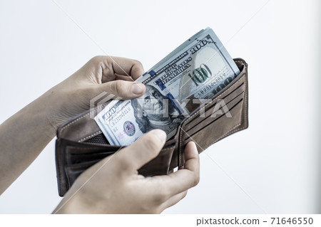 Businessman with a brown purse and a 100 dollar banknote, Saving money and spending using cash concept. Businessman with a brown purse and a 100 dollar banknote, Saving money and spending using cash concept. 71646550