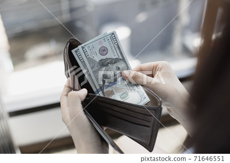 Businessman with a brown purse and a 100 dollar banknote, Saving money and spending using cash concept. 71646551