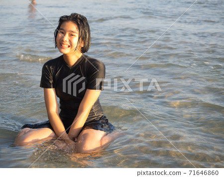 Teenage girl playing in the sea. 71646860
