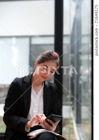 Businesswoman using her smartphone. Businesswoman using her smartphone. 71649175