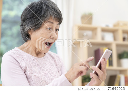 使用智能手機的高級女性 使用智能手機的高級女性 71649923