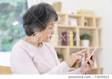 使用智能手機的高級女性 使用智能手機的高級女性 71649925