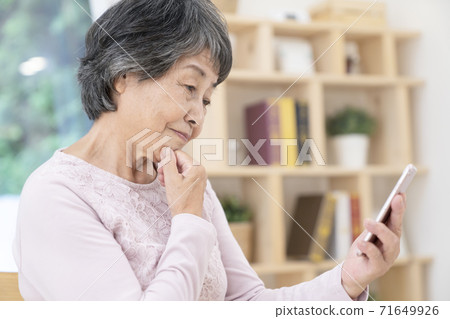 使用智能手機的高級女性 使用智能手機的高級女性 71649926