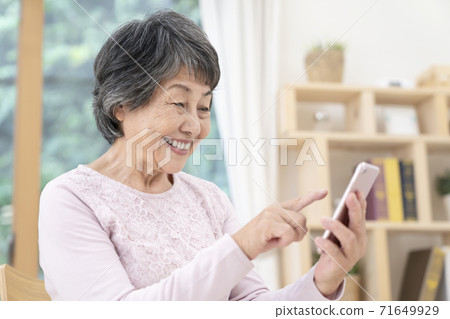 Senior female using a smartphone Senior female using a smartphone 71649929