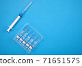 Vaccine for treatment of COVID-19 coronavirus with syringe on blue background with space for text. World vaccination against SARS-nCoV epidemic. Concept fighting and defeating coronavirus 2019-nCoV. 71651575