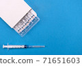 Vaccine for treatment of COVID-19 coronavirus with syringe on blue background with space for text. World vaccination against SARS-nCoV epidemic. Concept fighting and defeating coronavirus 2019-nCoV. 71651603