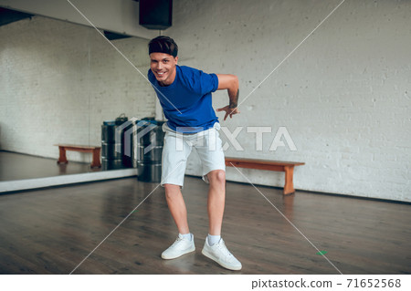 Man holding his hands behind the back while dancing Man holding his hands behind the back while dancing 71652568