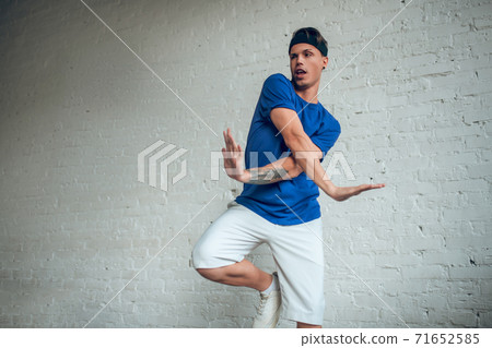 Man wearing blue t-shirt making dancing movements 71652585
