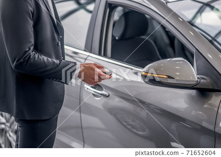 Close-up of male hand pressing car alarm button 71652604
