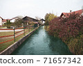 Small river goes in village between houses, autumn season. 71657342