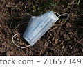 face mask drop on ground grass floor, save the nature. garbage. in time of coronavirus 71657349