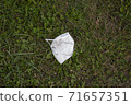 face mask drop on ground grass floor ,epidemic, save the nature. garbage. 71657351