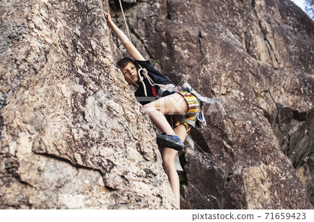 cute teen kid climbing on rock with insurance, lifestyle sport people concept cute teen kid climbing on rock with insurance, lifestyle sport people concept 71659423