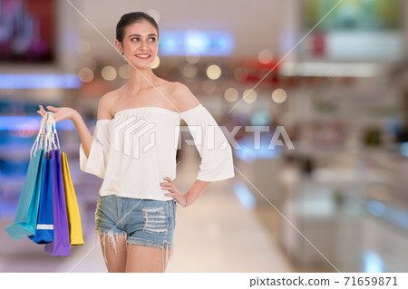 woman holding many colorful shopping bags over Shopping malls background.  71659871