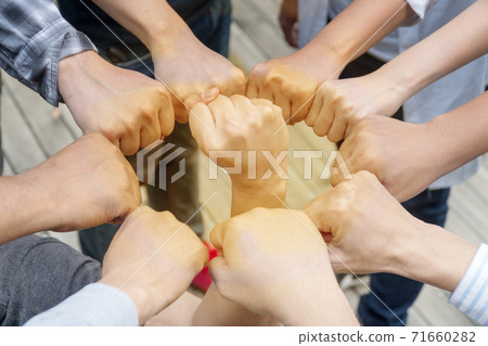 people putting their fists together by having a fist in the middle as symbol unity and achievement 71660282