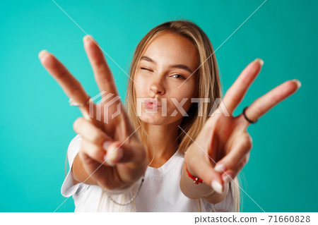 Young happy smiling woman showing victory sign. 71660828