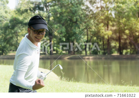 Golfers men hold fist his hand show joy results of the successful play on nature background. 71661022