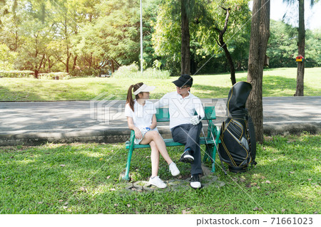Male and female golfers talking and plan for play golf in the lawn, sitting relax on chair  71661023